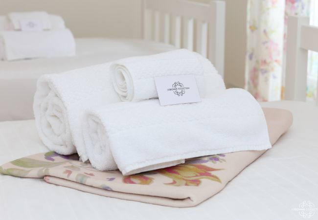 Serviette de bain pliées et posées sur le lit avec carton