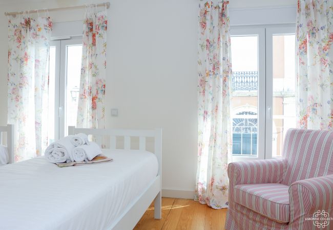 Chambre lumineuse avec deux lit simple, un canapé simple et accès au balcon 