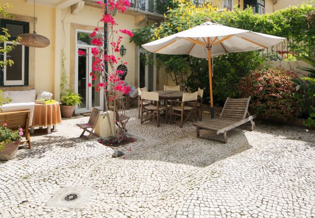 jardin typique et chaleureux en plein centre de Lisbonne avec table et chaises longues