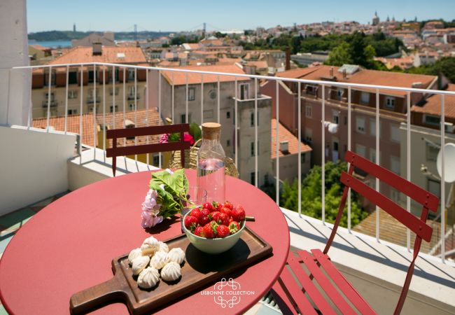 terrasse aménagée avec mobilier rouge et large panorama sur Lisbonne